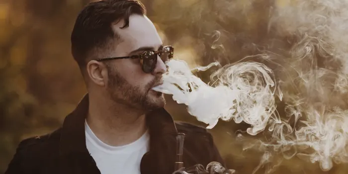 タバコの煙を吐き出す男性