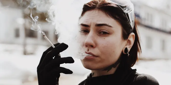 タバコの煙を吐き出す女性