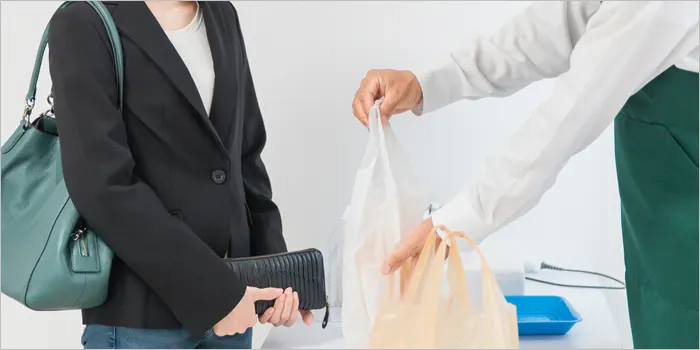 コンビニで接客をする男性店員と女性の客