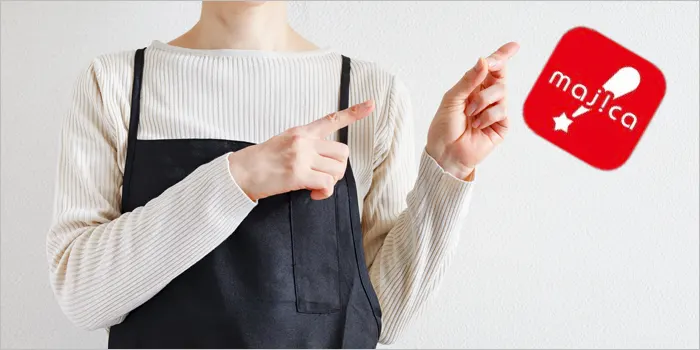 マジカアプリを指さすエプロン姿の女性