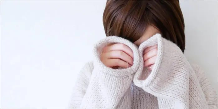 手で顔を覆い隠す女性