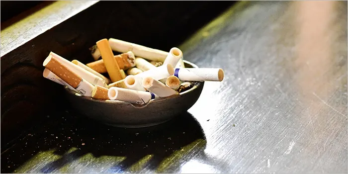 灰皿に入った大量のタバコ