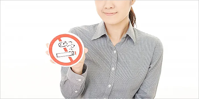 禁煙マークを持つ女性の手