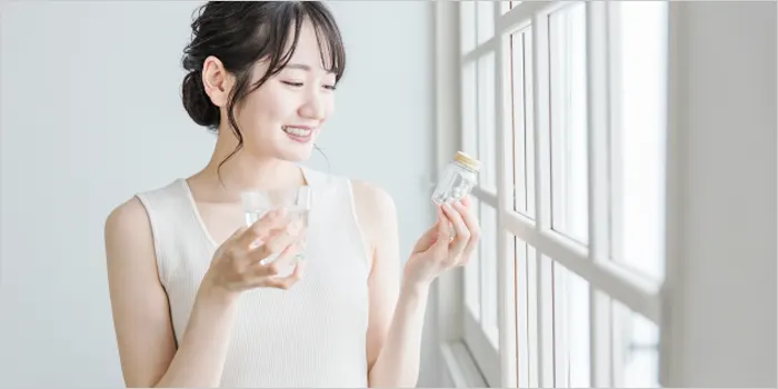 サプリメントを飲む女性