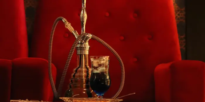 赤い椅子を後ろにシーシャとお酒の写真