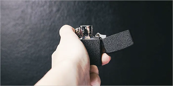 ジッポライターを持つ男性の手