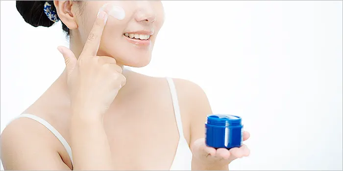 頬にクリームを塗る女性