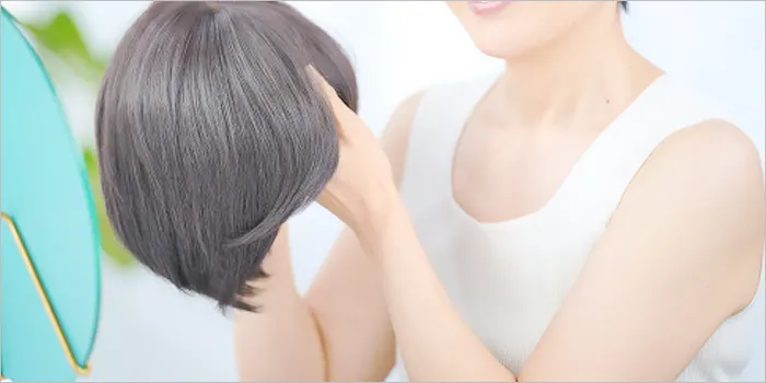 ウィッグを手に取る女性